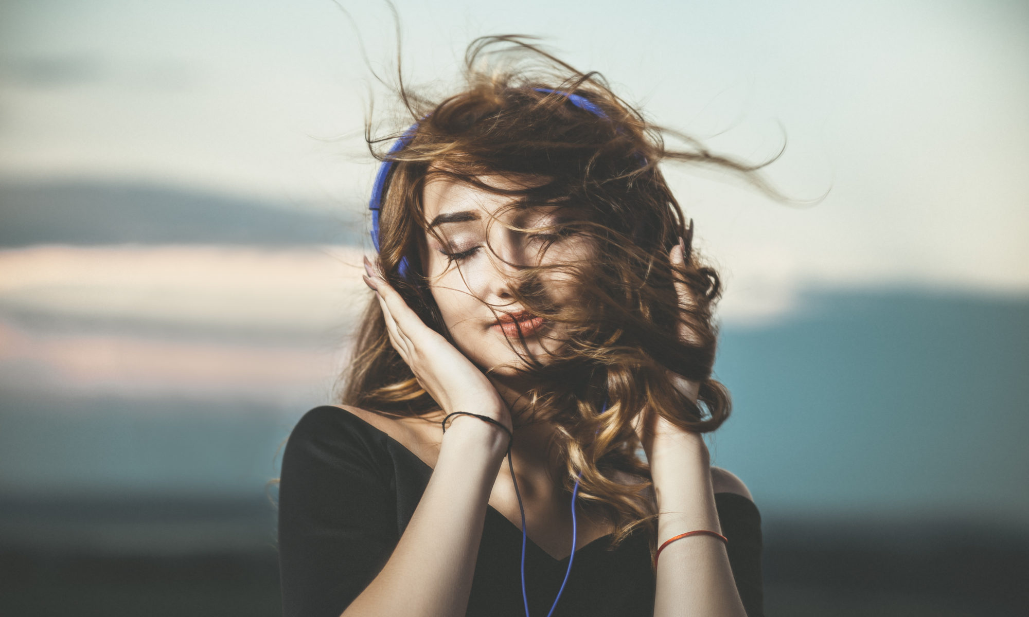 dziewczyna słuchająca muzyki na słuchawkach na zewnątrz